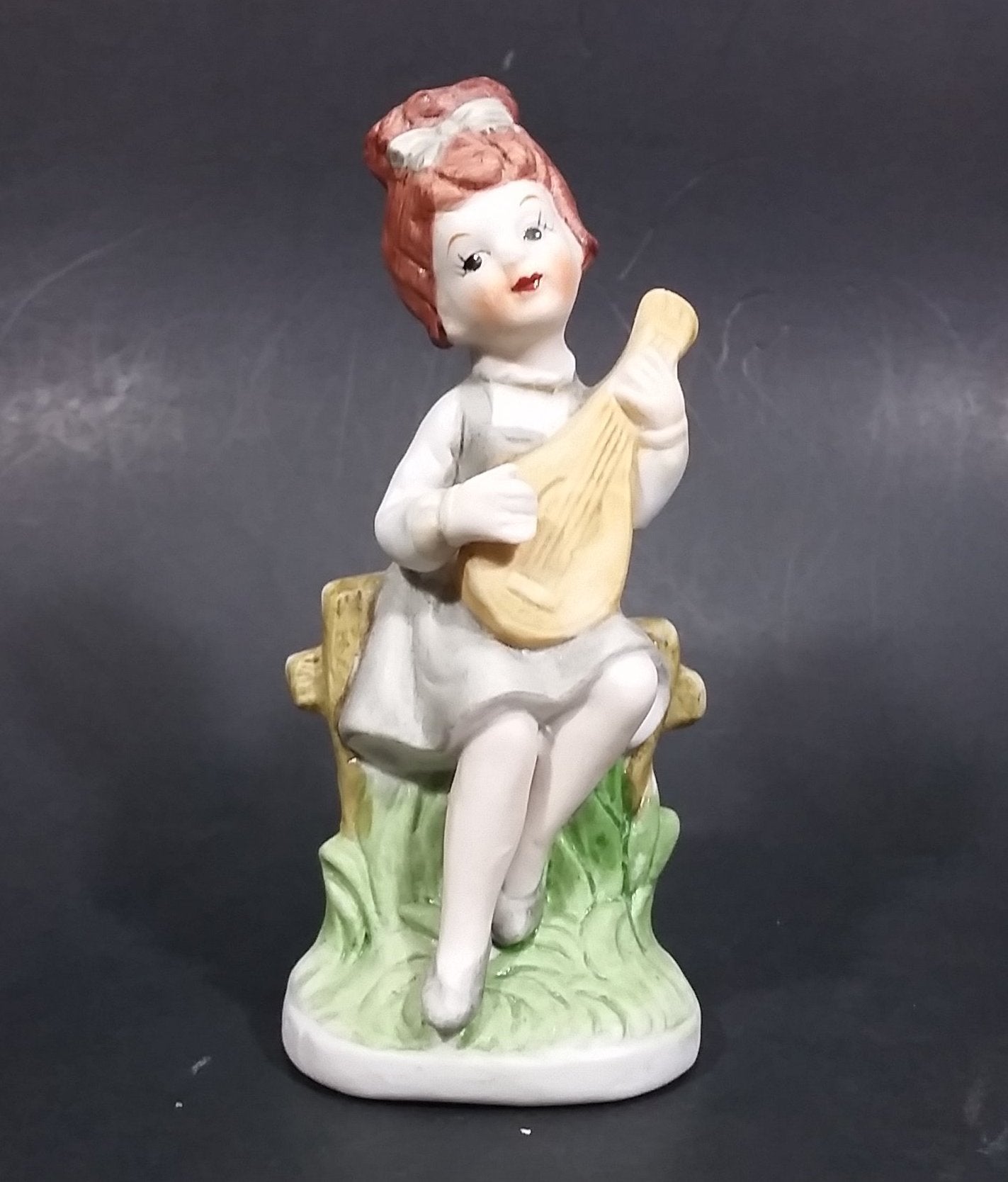 Vintage Victorian Girl Sitting on a Fence Playing a Mandolin Ceramic Figurine